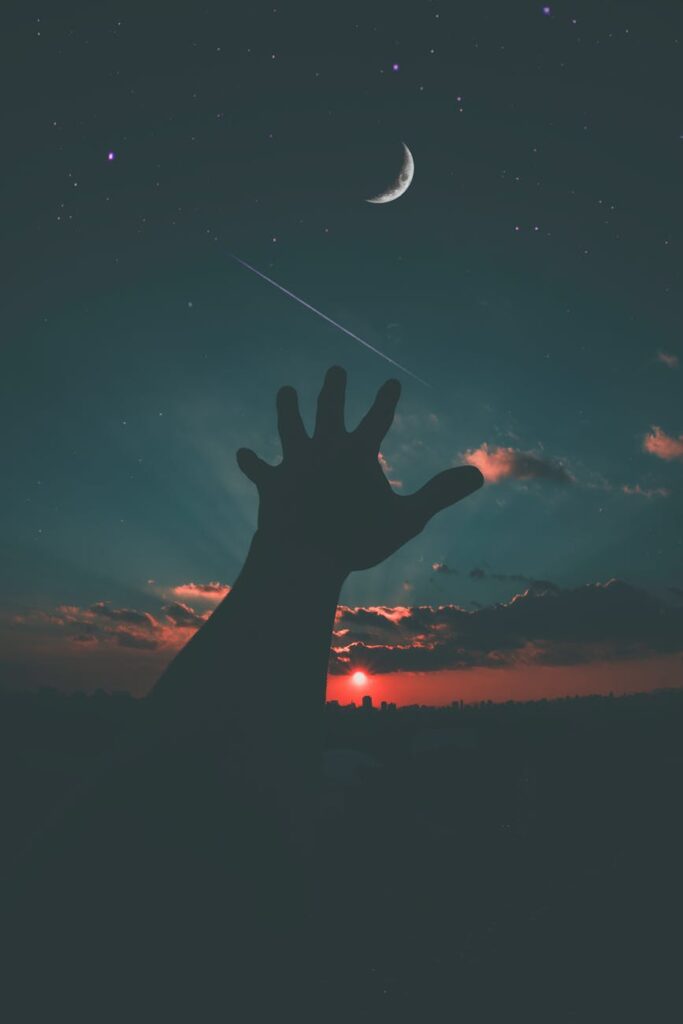 person hand and crescent moon